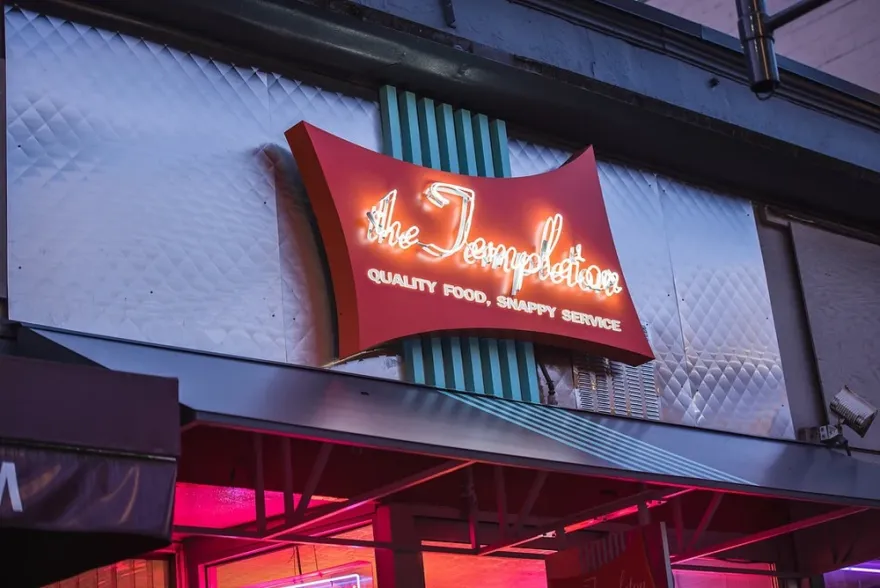 The Templeton sign: white neon script on a curved red panel above a diner awning
