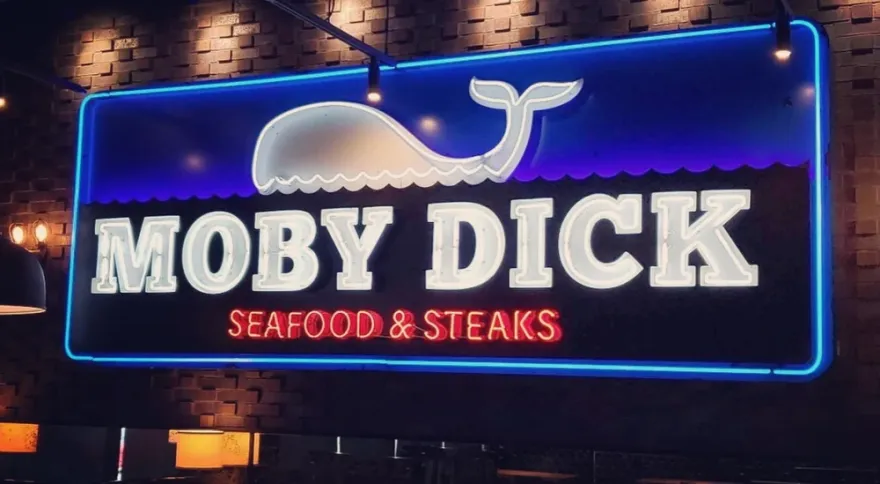 Moby Dick Seafood & Steaks neon sign: white whale and lettering inside a blue neon border