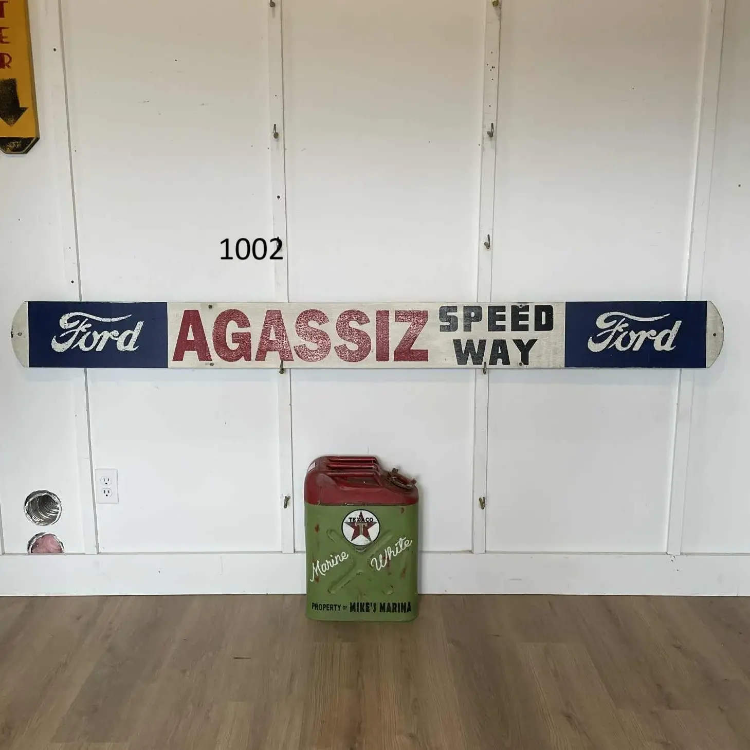 Long hand-painted wood board reading Ford / Agassiz Speedway, about 83 inches end to end